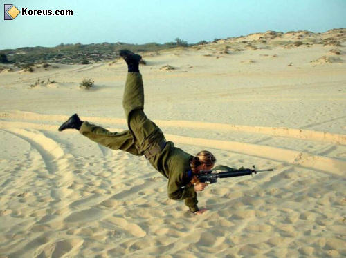 image femme sable plage figure guerre arme à feu armée humour insolite