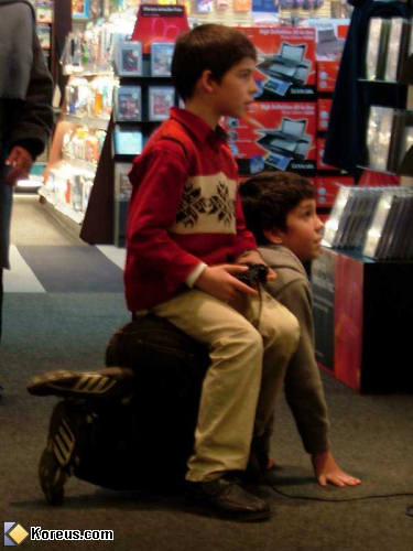 photo enfant joue jeu vidéo assis sur dos copain 4 pattes humour insolite