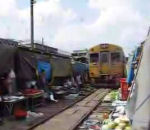 bangkok train Un train traverse le marché de Bangkok