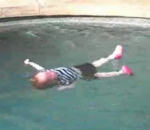piscine Un bébé jeté à l'eau se retourne sur le dos