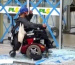 fauteuil roulant Un homme en fauteuil roulant défonce une vitrine