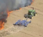 tracteur feu Un agriculteur fait un coupe-feu en tracteur