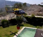 bombardier incendie Un hélicoptère des pompiers remplit son seau dans une piscine