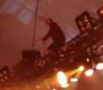 concert Un chanteur fait un saut depuis une traverse d'éclairage