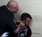 policier homme Un gardien de prison plaque la tête d'un détenu contre un mur
