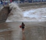 femme plage Une femme emportée par une vague