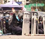 grenade manifestation Un policier antiémeutes tente d'écarter une grenade