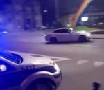 drift rond-point Une BMW M3 drifte dans un rond-point devant une voiture de police
