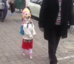 deguisement Un chien déguisé en petite fille marche sur ses pattes arrière