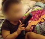 bebe maman Un bébé s'amuse avec un pistolet