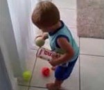 balle enfant Un enfant déterminé range des balles de tennis
