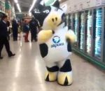 supermarche Une mascotte vache danse dans un supermarché