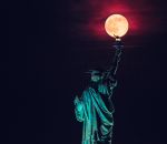 solstice La Lune Rose posée sur la torche de la Statue de la Liberté