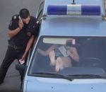 pied femme Une femme défonce le pare-brise d'une voiture de police