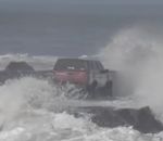vague houle Une voiture sur une jetée au milieu des vagues