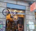 velo vtt Ne pas accrocher son vélo au rideau en fer d'une boutique