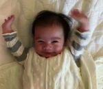 bebe Un bébé lève les bras en l'air au réveil