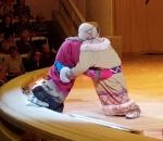 main enfant Deux lutteurs se livrent en spectacle sur une scène (Russie)