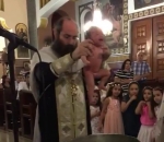eglise pretre Un prêtre baptise vigoureusement un bébé