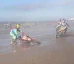 course moto Motard en panne pendant le départ d'une course sur une plage