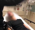 claque policier lit Un policier frappe un homme sur un lit d'hôpital