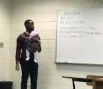 professeur cours Un professeur porte le bébé d'un de ses élèves pour qu'il puisse prendre des notes
