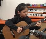 enfant Miumiu chante « Fly Me to the Moon » à la guitare
