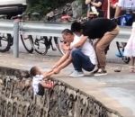 vide Un papa suspend son fils au-dessus du vide pour une photo
