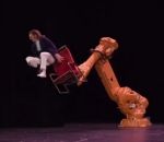 theatre Un acrobate et une chaise contrôlée par un bras robotique