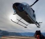 helicoptere atterrissage Un hélicoptère se pose face à un bûcheron