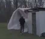 homme toit Renforcer le toit d'un cabanon pendant une tempête