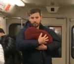 metro homme Faire semblant de tenir un bébé dans ses bras dans le métro