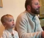 enfant papa imitation Un enfant de 2 ans regarde un match avec son père