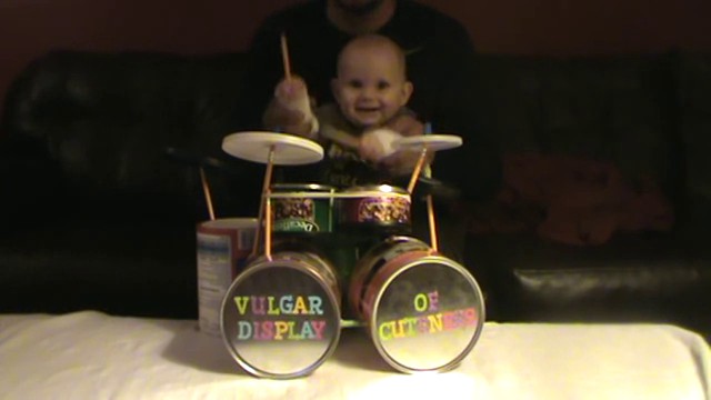 Un bébé joue de la batterie