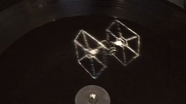 Un TIE Fighter et le Faucon Millenium en hologramme sur le double vinyle de Star  Wars 7