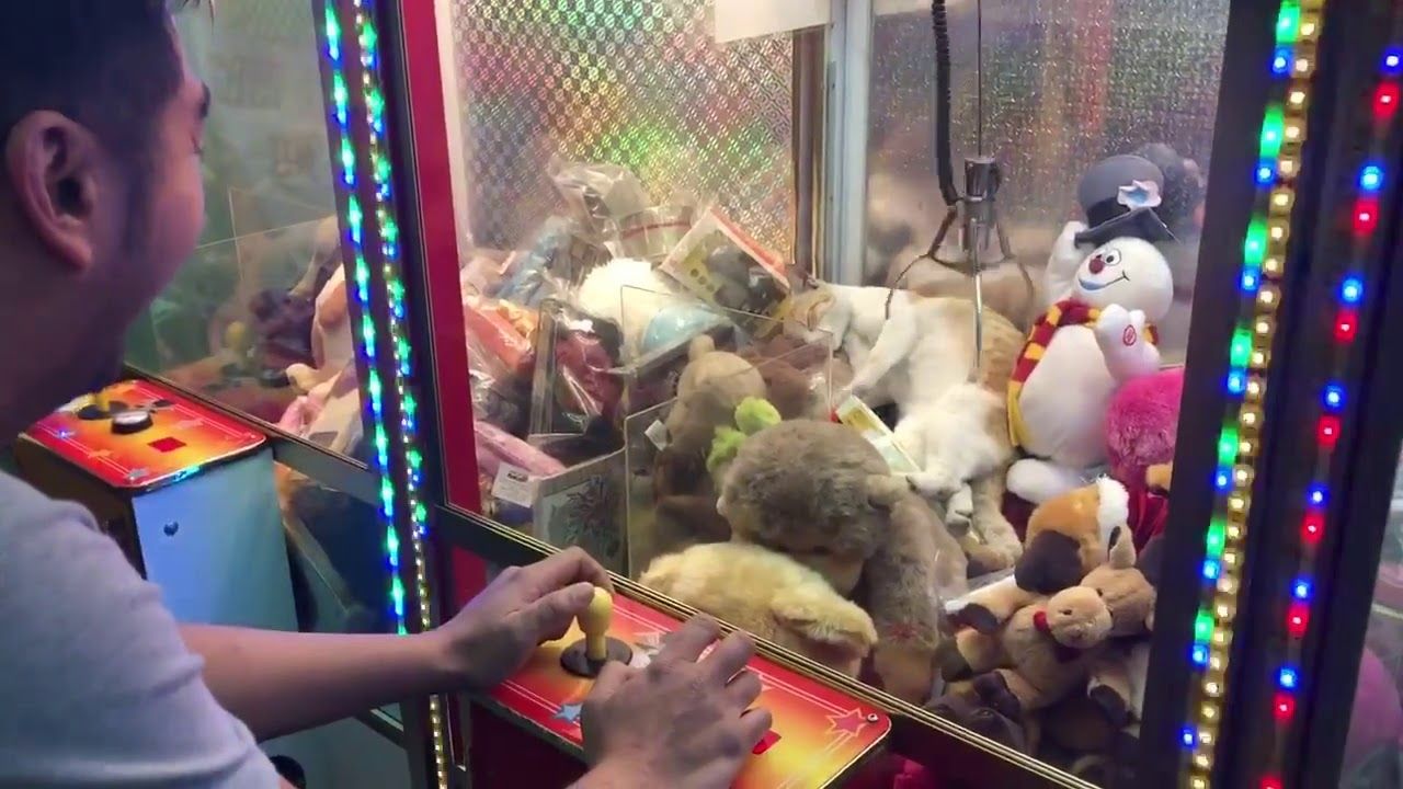 Un homme jouant sur une machine à pince gagne une peluche à laquelle il  ne s'attendait pas (vidéo)