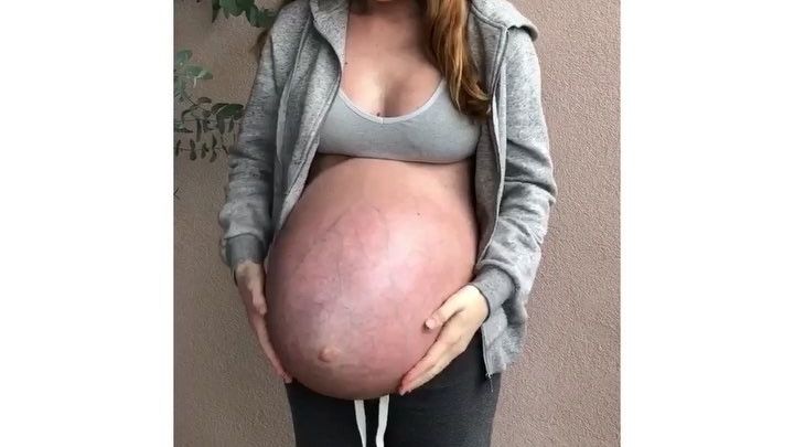 Le ventre d'une femme enceinte de triplés