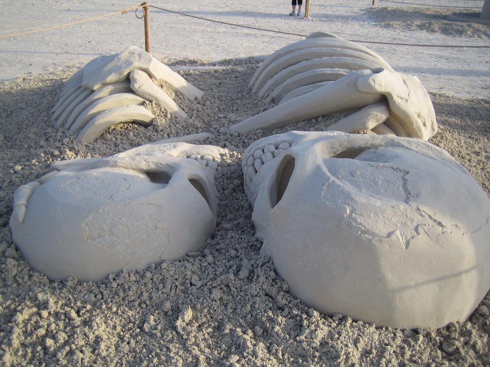 Un couple de squelettes se donnent la main (Sculpture sur sable)