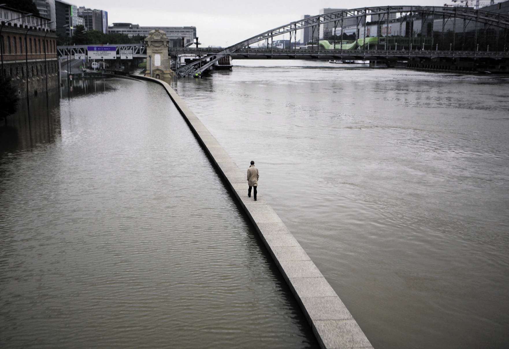 Un homme seul sur un muret au milieu de la Seine inondée