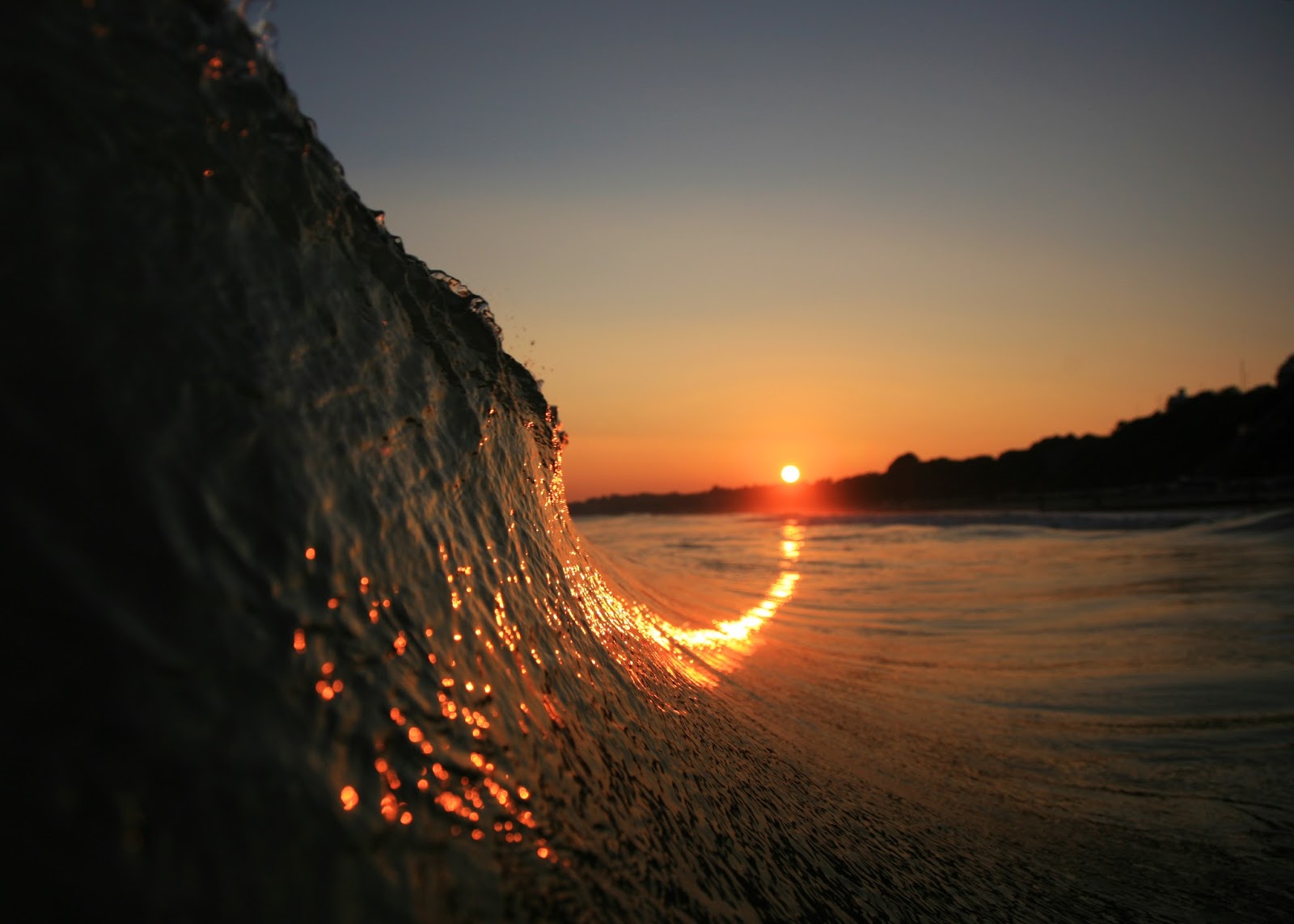 Le reflet du soleil couchant dans une vague