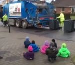 assis Des enfants regardent des éboueurs