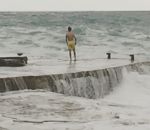 ponton vague homme Il se jette dans une mer déchainée
