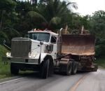 colline Un camion transportant un bulldozer glisse sur une colline