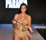 mannequin Une mannequin défile en allaitant son bébé