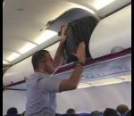 ranger passager Un passager veut ranger sa valise dans un avion