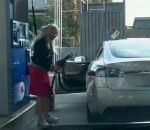 essence station-service Une blonde en Tesla dans une station-service