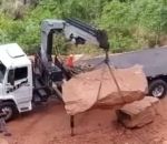 grue Régis charge un rocher sur un camion